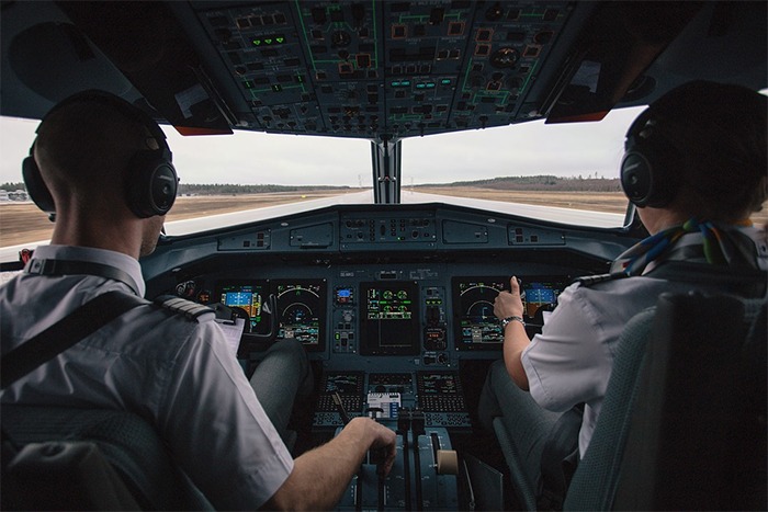 pilots controlling the plane in the cockpit