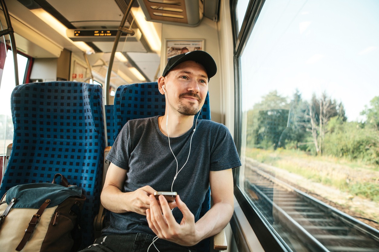 A man on a train wearing a T-shirt