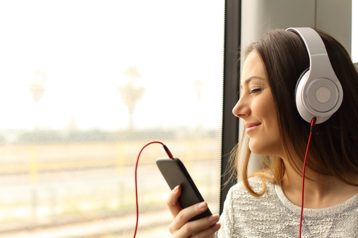 A woman on a train wearing a headphone