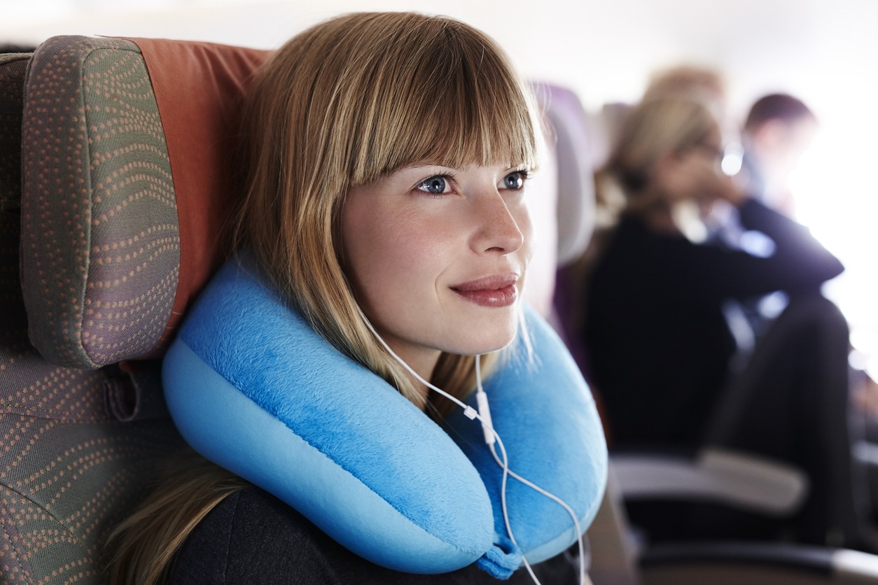 A woman wearing a neck pillow