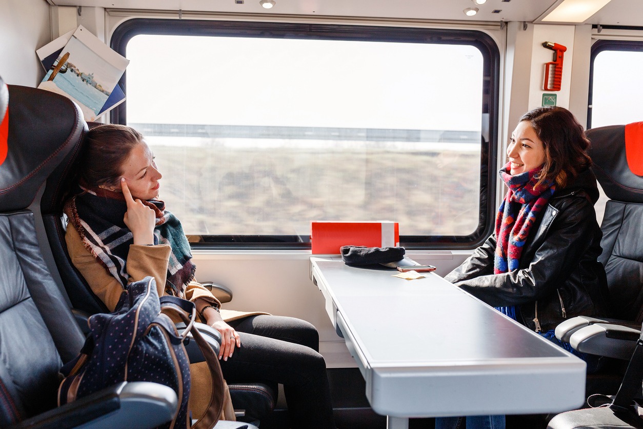 Two women sitting on comfortable chairs on a train