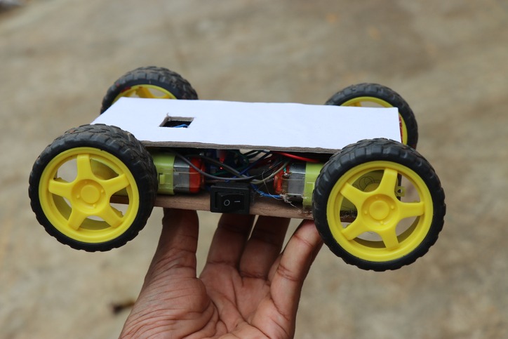 Wireless remote controlled robotic car made for science project. Robot car working model in hand