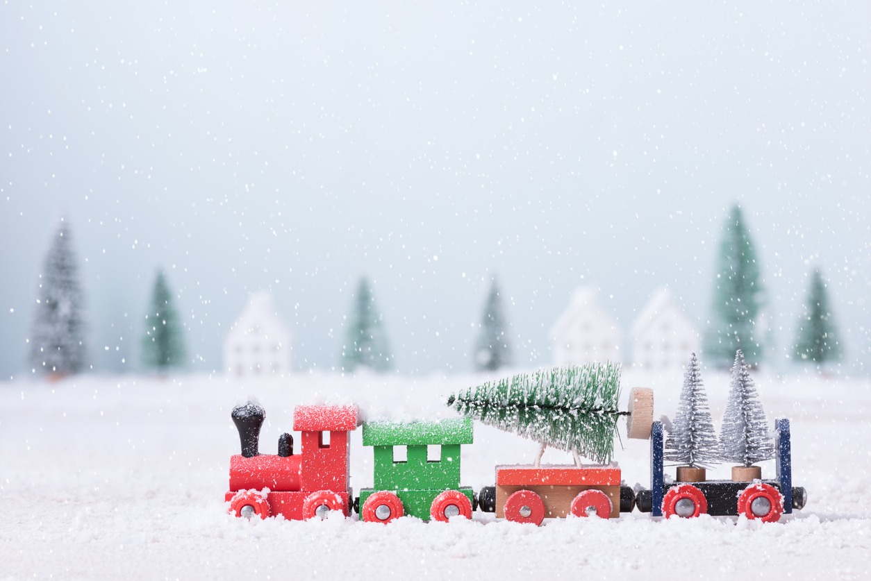 Christmas tree on toy train was running through the snow in the field of natural Landscape background