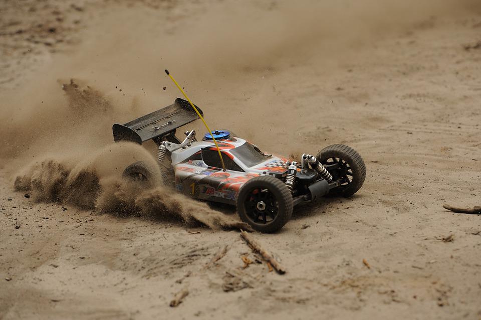 an RC car racing on sandy ground