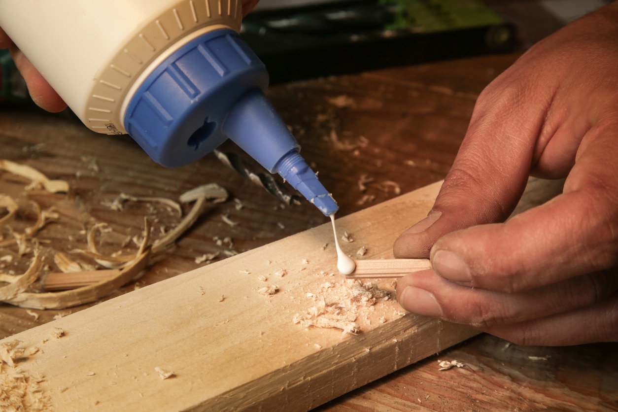 a man assembling wooden pieces with a glue