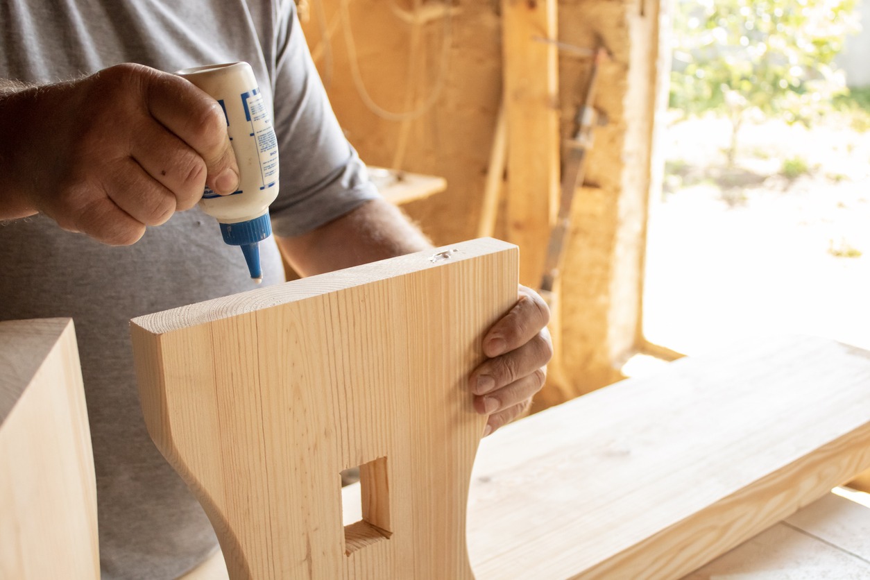 man applying glue on wood