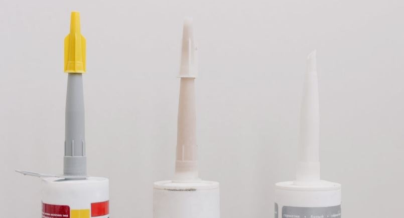 the tips of three glue bottles