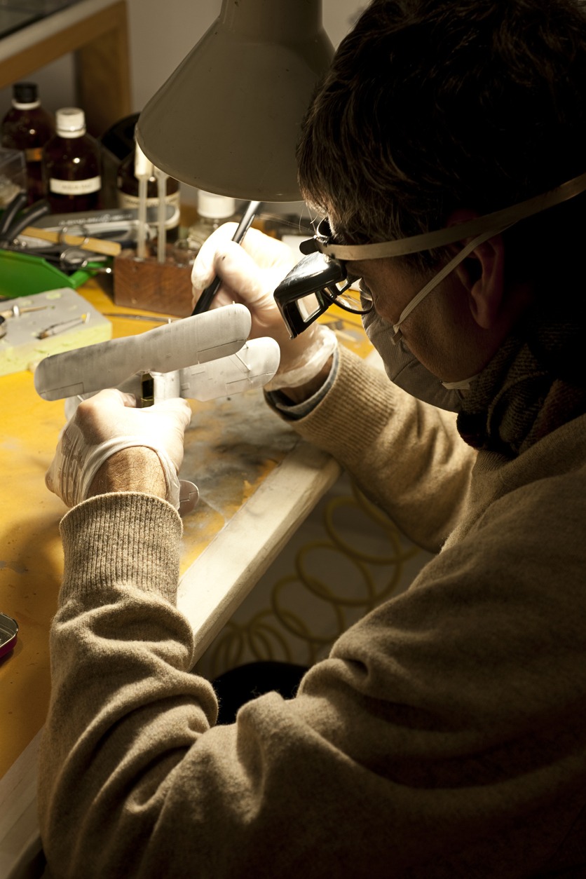 working desk of a man with a gray model airplane