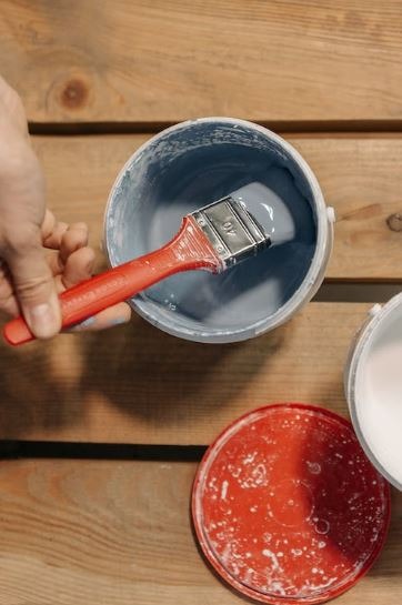 A paintbrush in a paint bucket