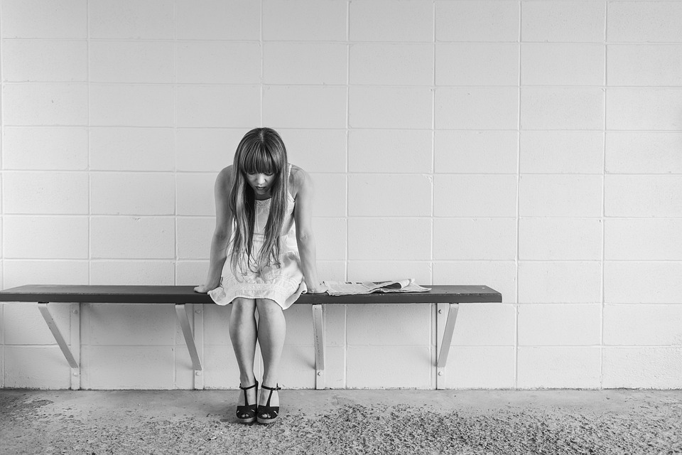 Stressed woman sitting on a bench at the platform
