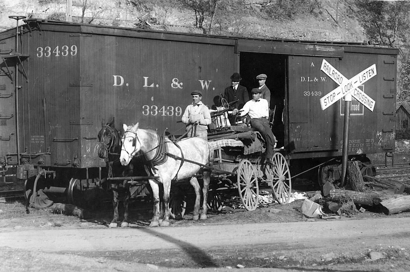 A Delaware, Lackawanna, and Western Railroad wagon at a level crossing, circa 1900.