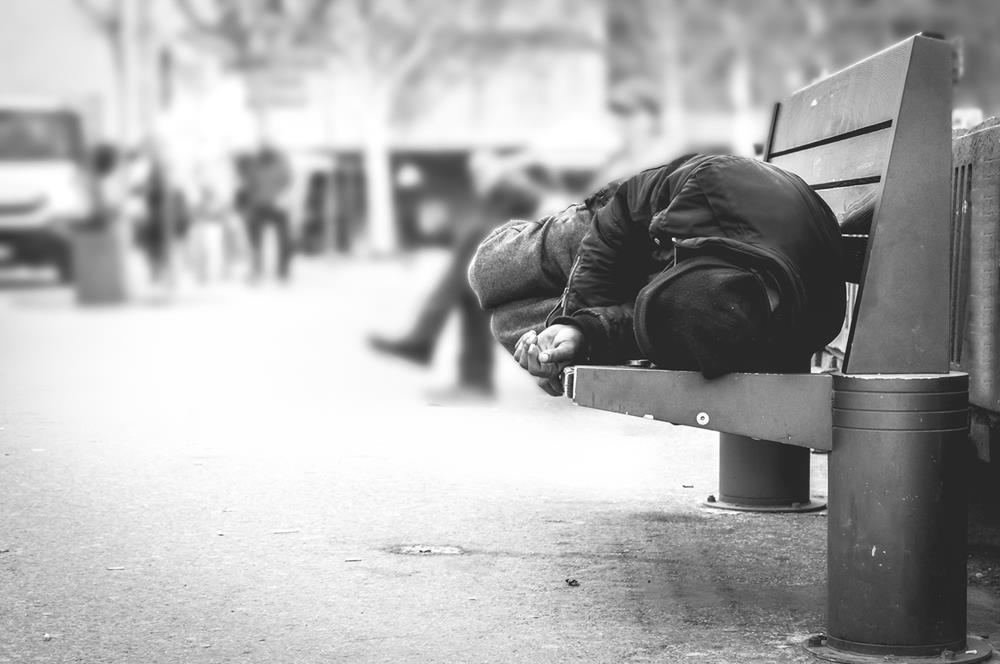 A hobo sleeping on the bench