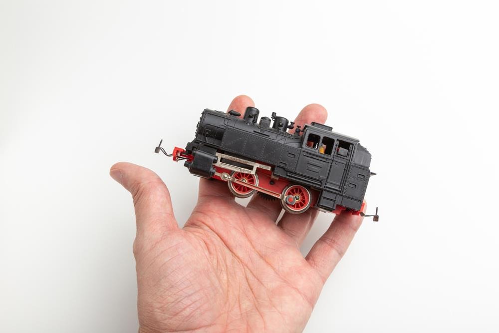 A model of a toy steam locomotive in hand