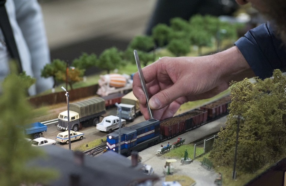 a person tinkering with train set