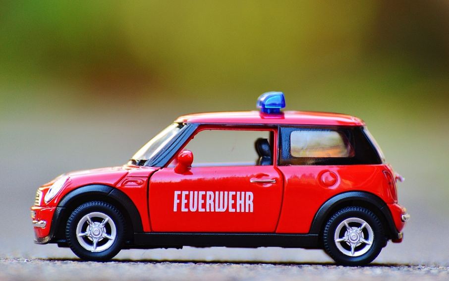 a tiny red service car with blue lights 